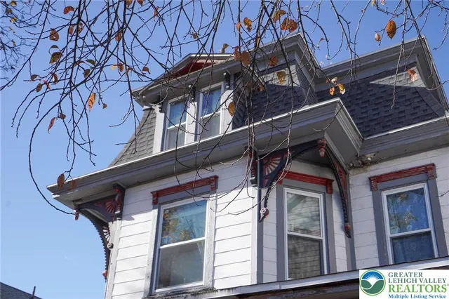 a view of an empty room with a fireplace and a window