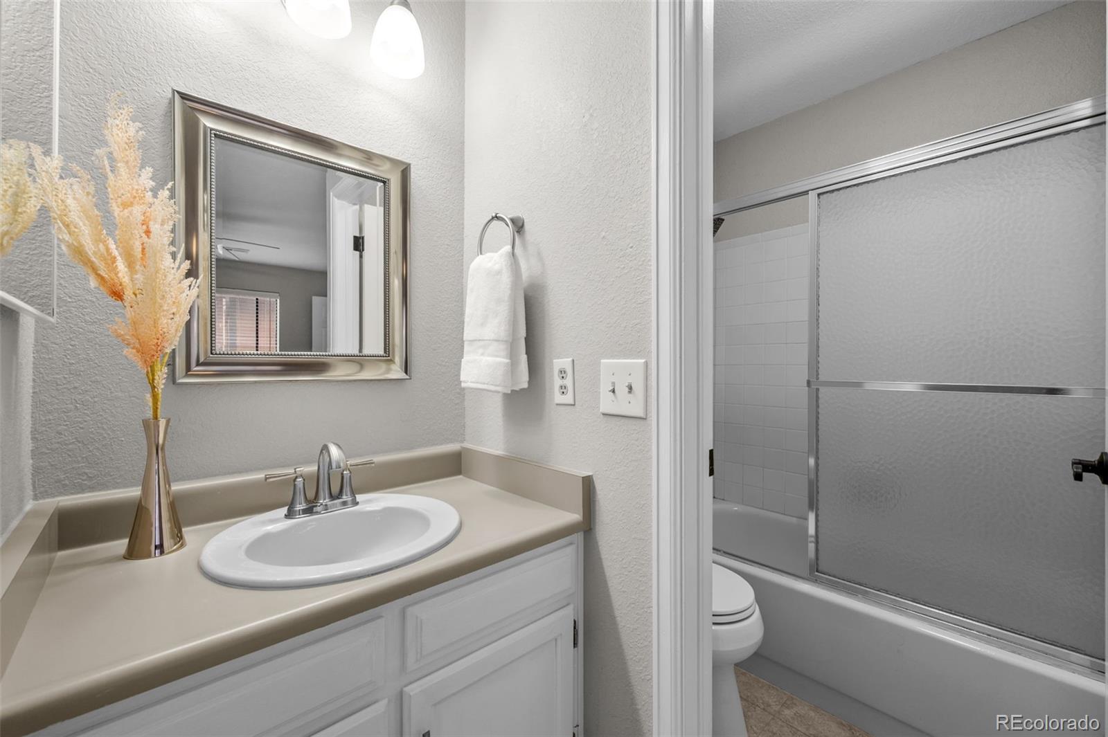 9409 West 89th Circle Broomfield, CO 80021 - Photo 14 of 22 a bathroom with a sink toilet and shower