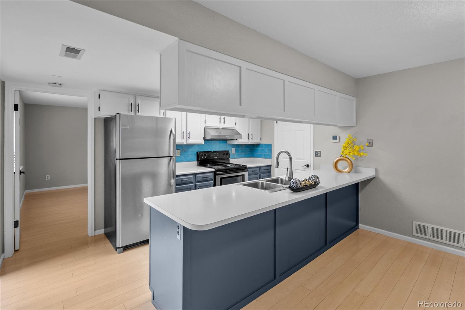 9409 West 89th Circle Broomfield, CO 80021 - Photo 8 of 22 a kitchen with refrigerator and cabinets