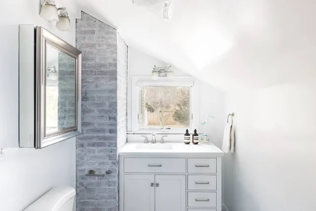 a bathroom with a sink mirror and a window