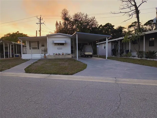 a front view of a house with a garden and trees