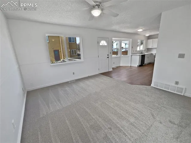 a view of a livingroom with a kitchen and window