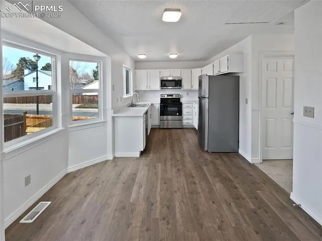 a kitchen with a refrigerator and a stove top oven