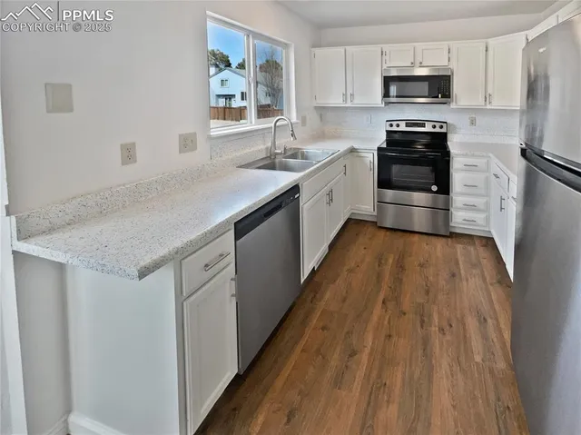 a kitchen with stainless steel appliances granite countertop a sink dishwasher stove and refrigerator