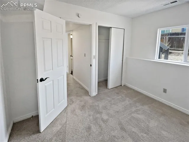 an empty room with windows and closet