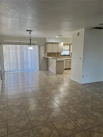 a view of a kitchen with windows and white cabinets