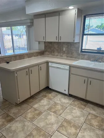 a kitchen with a sink window and cabinets