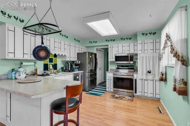 a kitchen with stainless steel appliances a stove refrigerator sink and cabinets