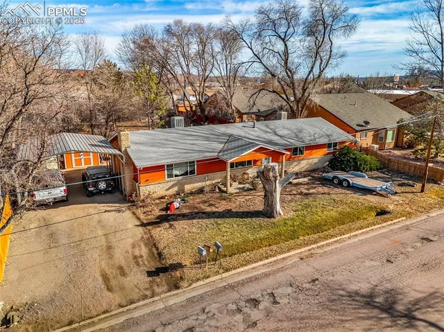 an aerial view of a house with a mountain
