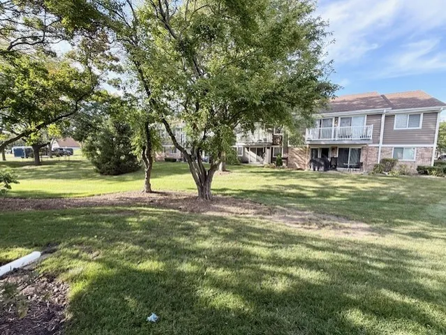 a view of a house with a big yard and large trees
