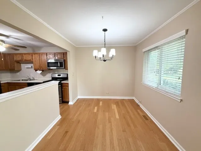 a kitchen with granite countertop wooden floors a refrigerator and a sink