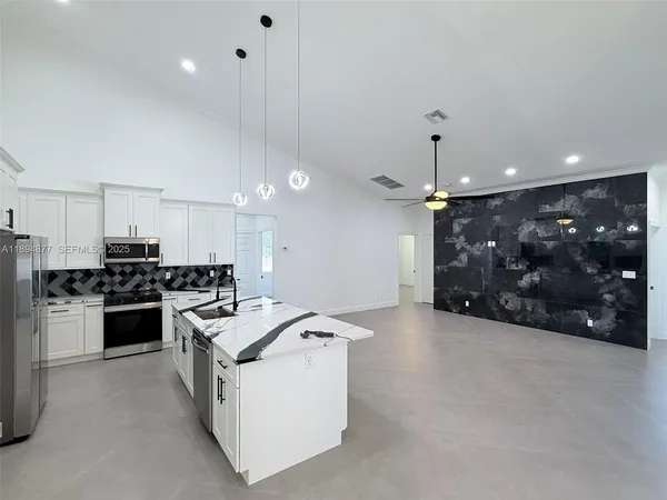 a view of a living room and chandelier kitchen view