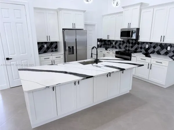 a kitchen with stainless steel appliances a stove refrigerator sink and microwave