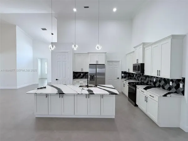 a kitchen with stainless steel appliances kitchen island granite countertop a sink and cabinets
