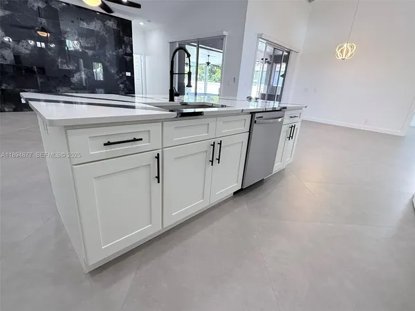a kitchen with white cabinets and sink