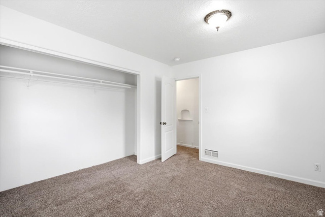 1341 29th Street Ogden, UT 84403 - Photo 20 of 37 Carpeted interior room featuring a white door, overhead ceiling light fixture, white walls, and a closet with wire shelving