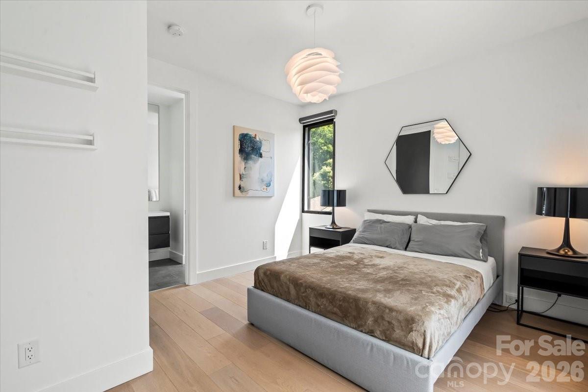 1620 South Tryon Street Charlotte, NC 28203 - Photo 14 of 29 a bedroom with a bed and a chandelier