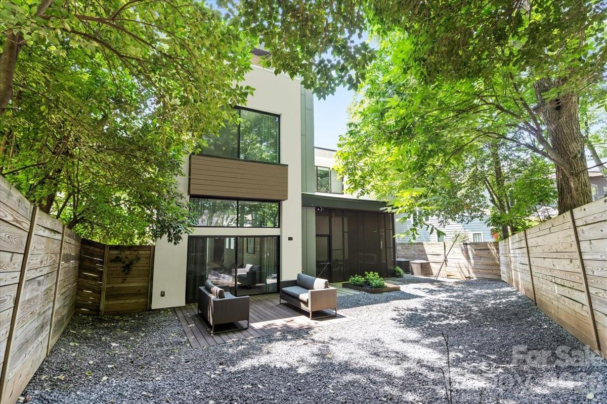 1620 South Tryon Street Charlotte, NC 28203 - Photo 27 of 29 a view of a bench in the backyard with large tree and wooden fence