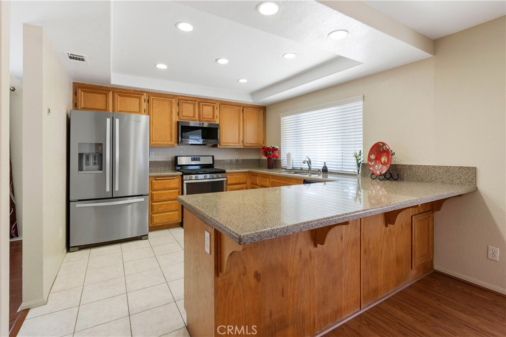 6879 Mission Grove Parkway North Riverside, CA 92506 - Photo 18 of 53 a kitchen with stainless steel appliances granite countertop a sink a refrigerator and a stove