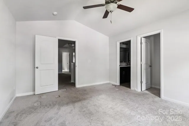 an empty room with closet and windows