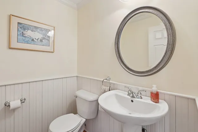 a bathroom with a toilet a sink and a mirror
