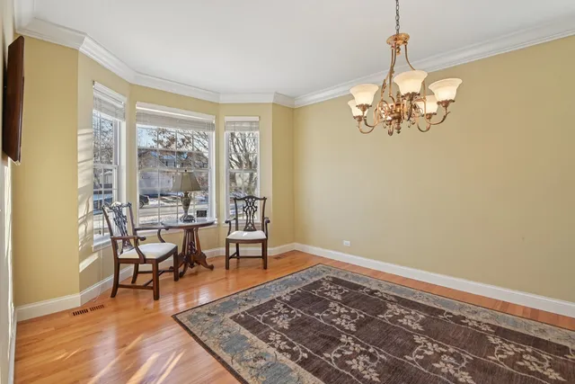 a view of a dining room with furniture a chandelier and wooden floor