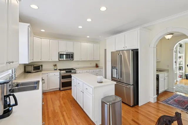 a kitchen with a refrigerator a sink and a stove top oven