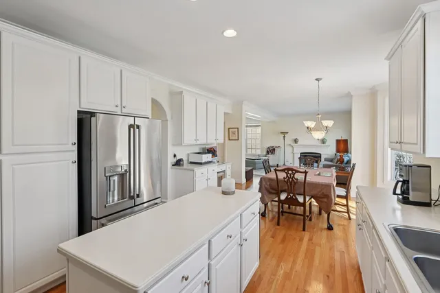 a kitchen with stainless steel appliances a refrigerator a table and chairs