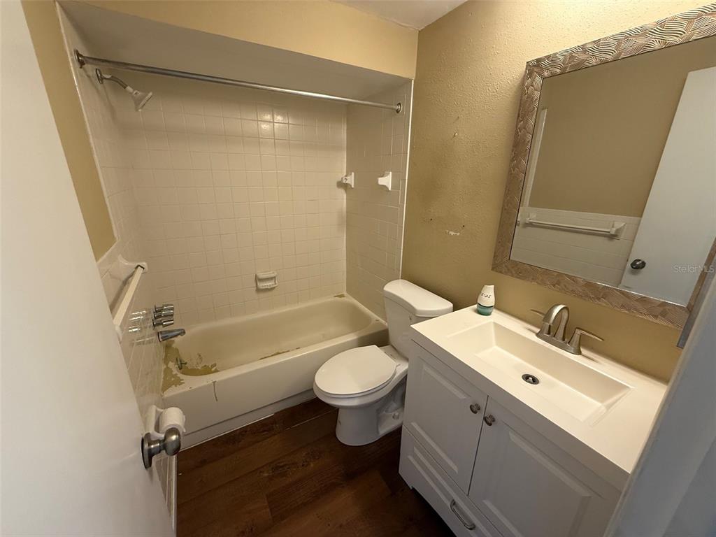 4233 Tamargo Drive, Unit 4233 New Port Richey, FL 34652 - Photo 9 of 13 a bathroom with a double vanity sink toilet mirror and shower