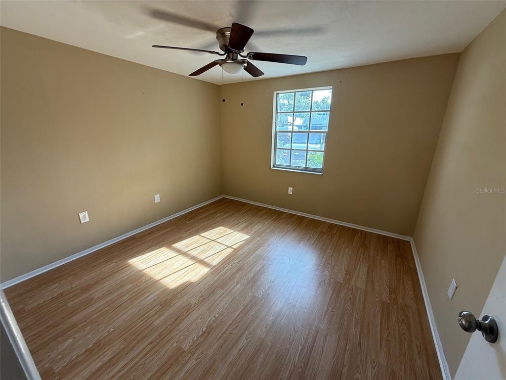 4233 Tamargo Drive, Unit 4233 New Port Richey, FL 34652 - Photo 10 of 13 a view of empty room with wooden floor and fan