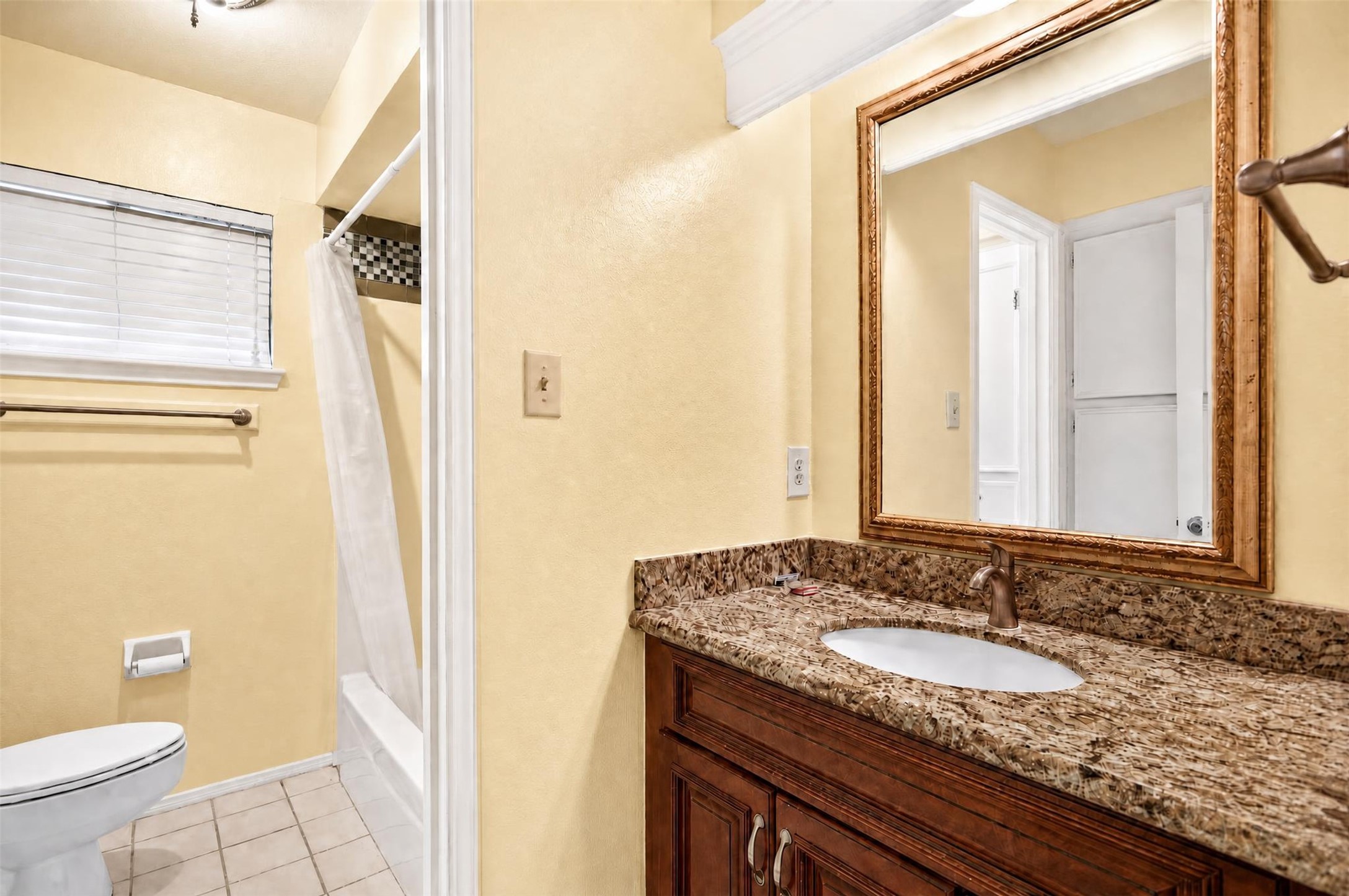 7019 Wyoma Trail Spring, TX 77379 - Photo 27 of 34 Upstairs secondary bathroom featuring a granite-topped vanity, elegant framed mirror, and a tiled shower area for a classic touch.