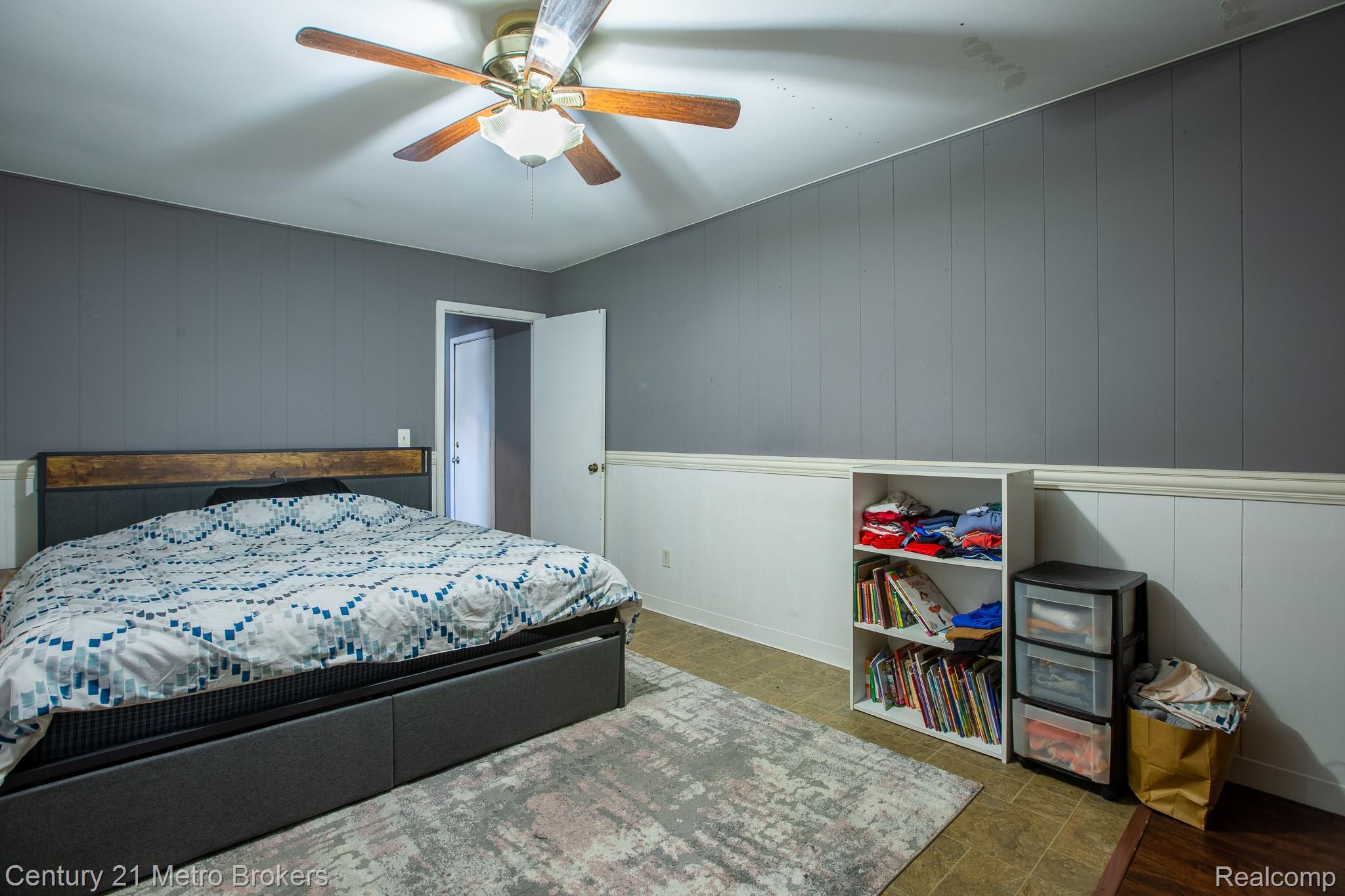 6101 Belsay Road Grand Blanc, MI 48439 - Photo 20 of 28 Bedroom featuring ceiling fan, wooden walls, and wood finished floors