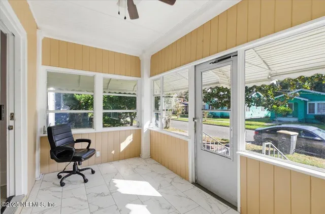 a view of a living room with a floor to ceiling window and wooden floor