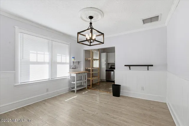 a view of empty room with wooden floor and windows