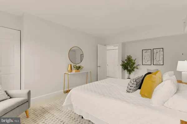 a bedroom with a bed lamps and couch