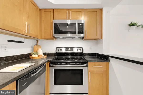 a kitchen with stainless steel appliances granite countertop a stove and a microwave