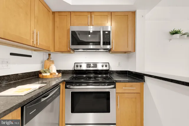 a kitchen with stainless steel appliances granite countertop a stove and a microwave