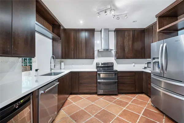a kitchen with granite countertop a sink stainless steel appliances and cabinets
