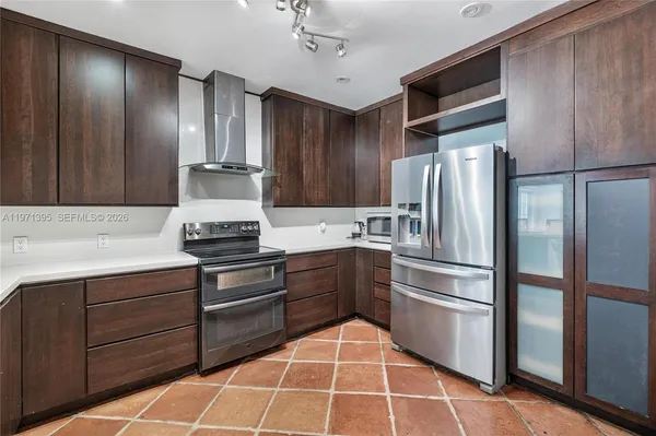 a kitchen with kitchen island a counter top space cabinets and stainless steel appliances