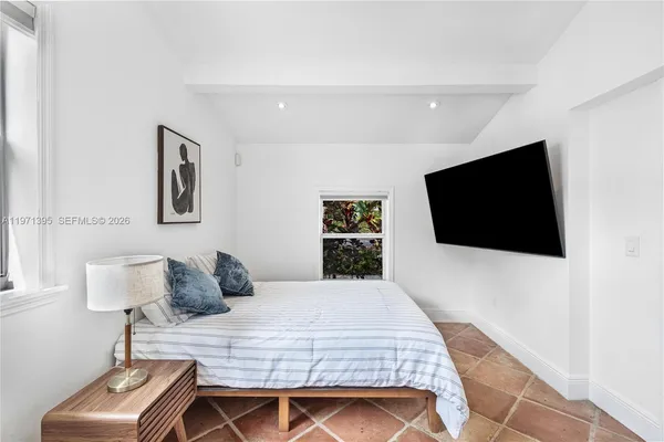 a bedroom with a bed and a flat screen tv