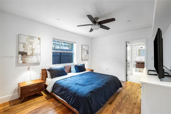a bedroom with a bed window and a flat screen tv