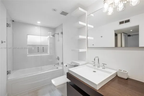 a bathroom with a sink a toilet a mirror and shower