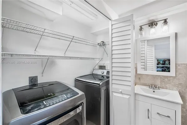 a utility room with sink dryer and washer