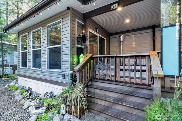 a view of a house with a large window and flower plants