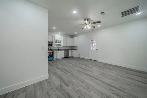 wooden floor in an empty room with a kitchen