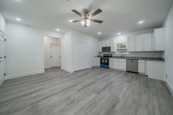 a view of kitchen with sink microwave and cabinets
