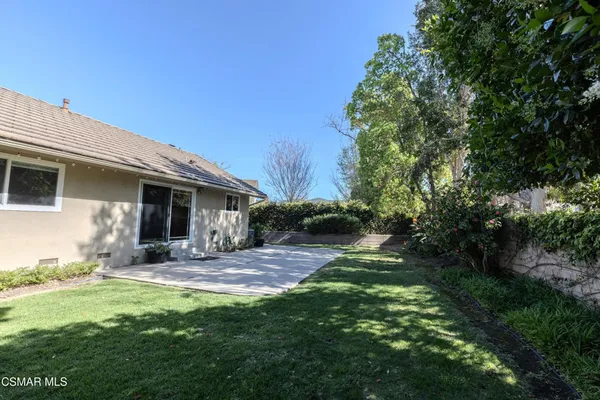 a backyard of a house with yard table and chairs
