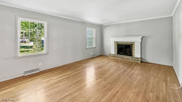6179 Case Road North Ridgeville, OH 44039 - Photo 3 of 29 Unfurnished living room featuring ornamental molding, wood finished floors, plenty of natural light, and a brick fireplace