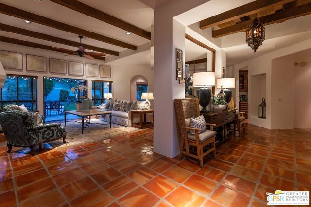 a living room with patio furniture and a chandelier
