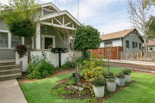 a front view of a house with a yard and potted plants